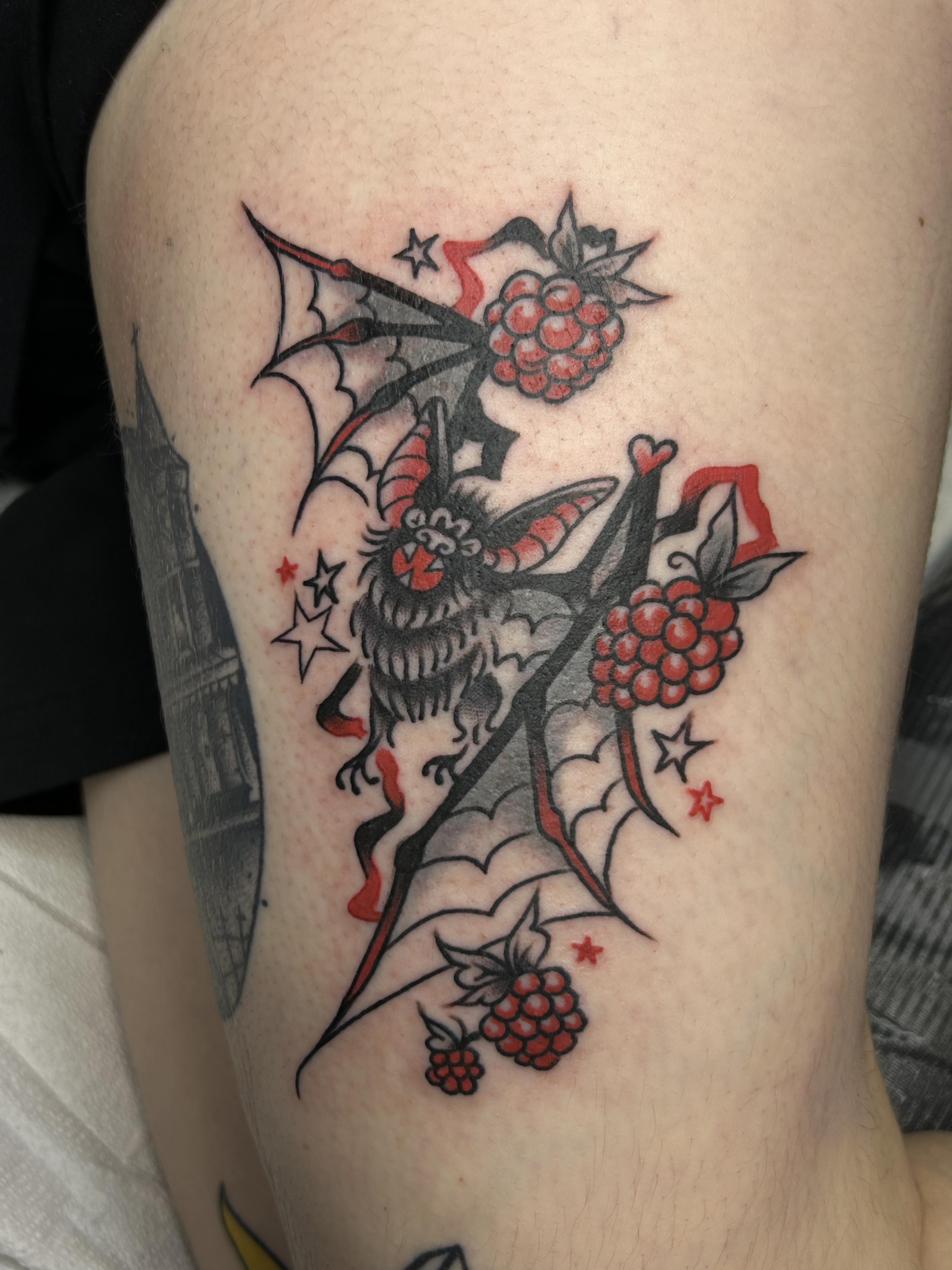 Colorful bat with berries tattoo by Leo Gielow who works at Resilience Body Arts in Maynard, MA